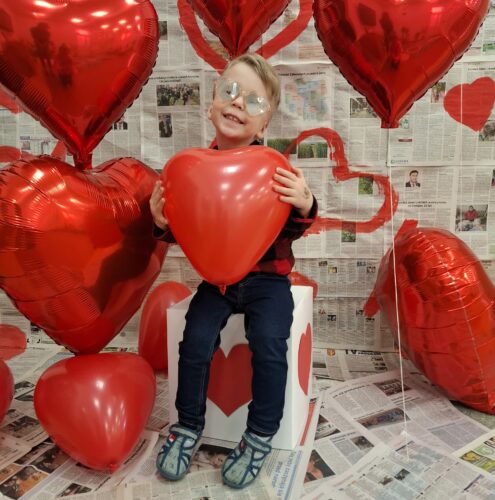 chłopiec trzyma serce balona
