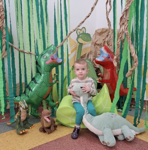 chłopiec z pluszowym dinozaurem